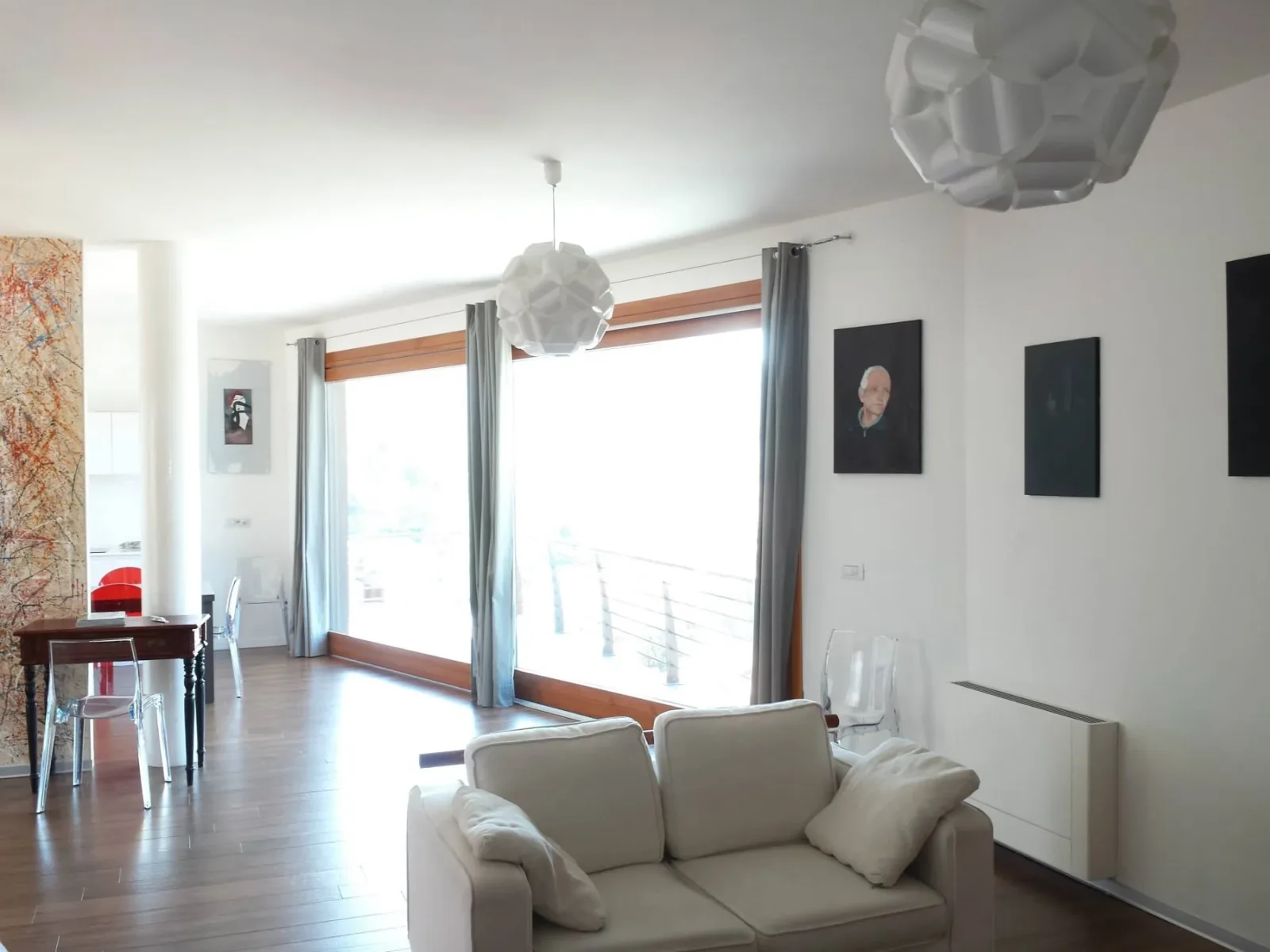Soggiorno con divano bianco e ampie aperture